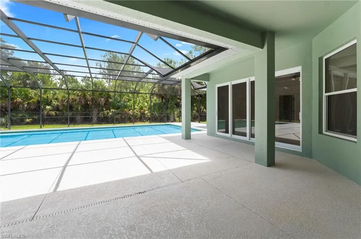 Screened outdoor living area featuring a rectangular pool and ample deck space
