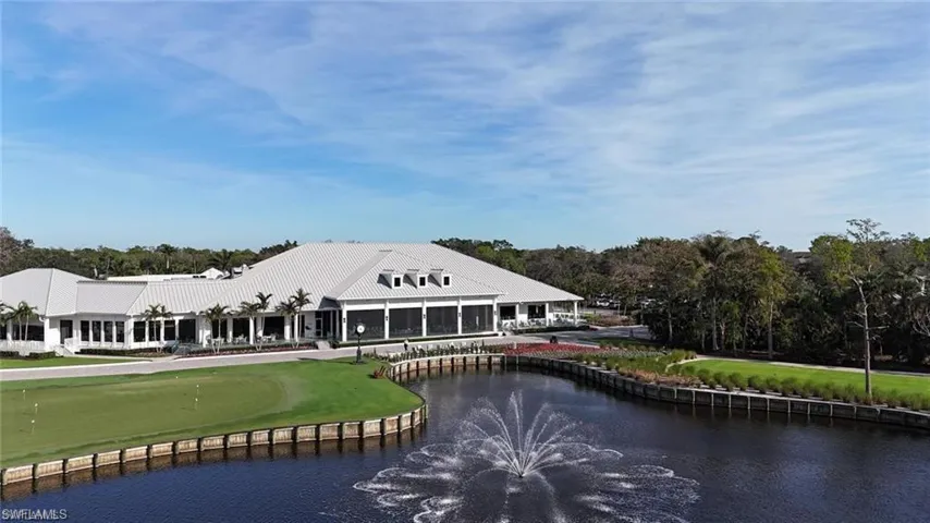 Rear view of house with a water view, golf course view, and view of scattered trees