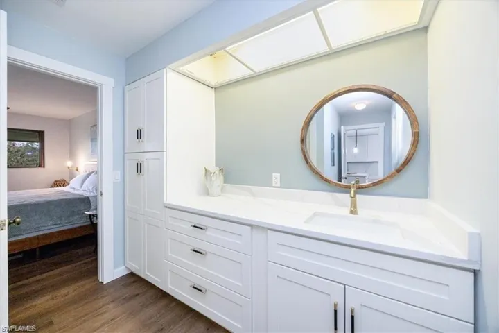 Ensuite bathroom featuring vanity and dark wood-style flooring