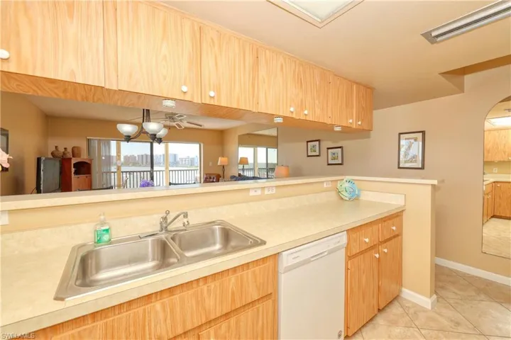 Kitchen with ceiling fan, sink, white dishwasher, and light tile patterned floors
