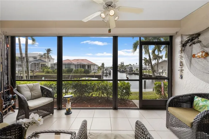 Sunroom / solarium featuring ceiling fan, a water view, and a wealth of natural light