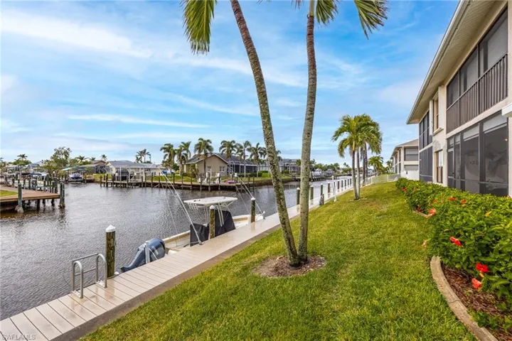 Dock area with a lawn and a water view
