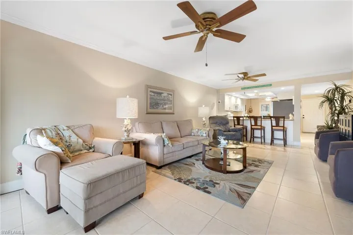 Living room featuring crown molding and light tile patterned floors
