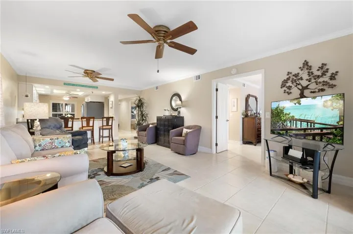 Living room featuring ornamental molding and light tile patterned flooring