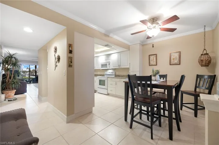 Dining area featuring crown molding, light tile patterned floors, and ceiling fan