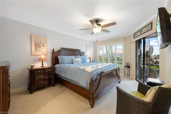 Bedroom featuring ceiling fan, light colored carpet, and crown molding