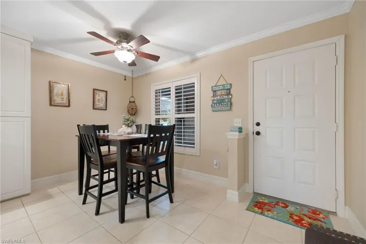 Dining room featuring ceiling fan, light tile patterned floors, and ornamental molding