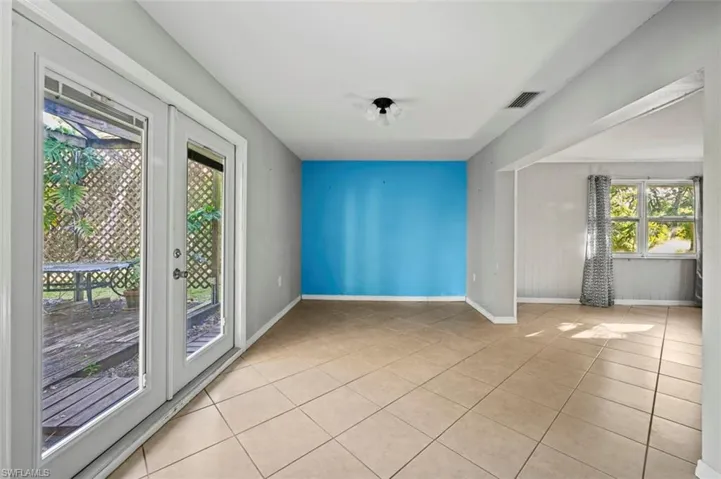Dinning room featuring a healthy amount of sunlight, light tile patterned floors, and french doors
