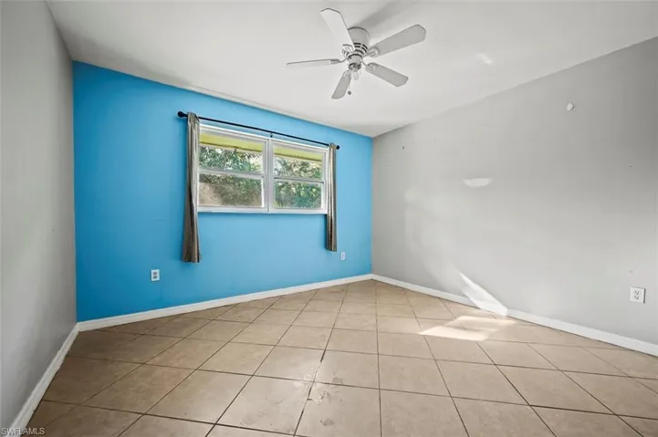 Bedroom with ceiling fan and light tile patterned flooring