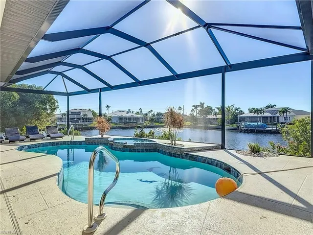 View of pool featuring glass enclosure, a sunroom, and a water view