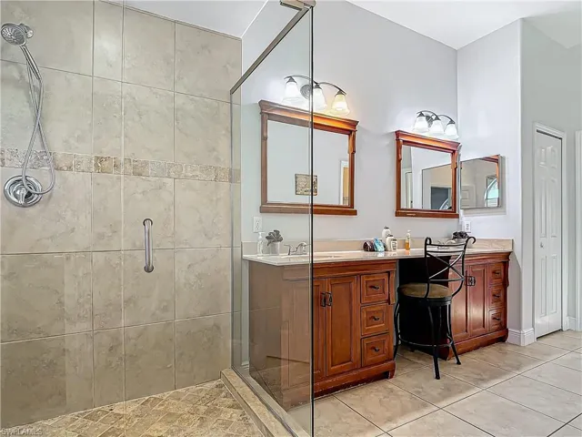 Bathroom with a stall shower, vanity, and light tile patterned floors