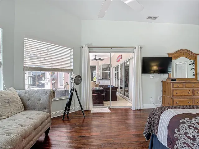 Bedroom featuring wood-type flooring, a ceiling fan, and access to outside