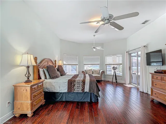 Bedroom featuring access to exterior, dark wood-type flooring, and ceiling fan