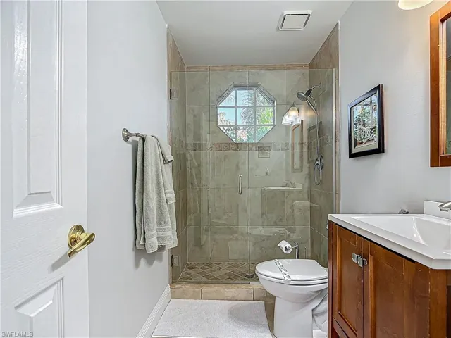 Bathroom featuring vanity, a shower stall, and light tile patterned floors