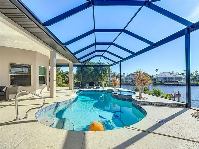 View of swimming pool with a sunroom, a patio, a water view, a pool with connected hot tub, and a lanai