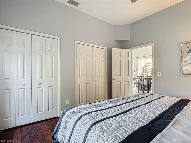 Bedroom with two closets and dark wood-style flooring