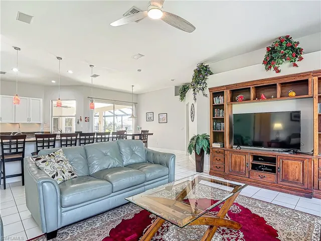 Living room featuring light tile patterned flooring, ceiling fan, and recessed lighting
