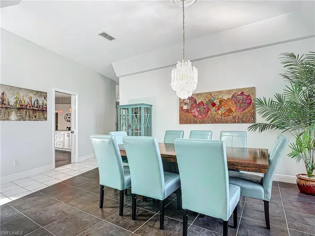 Dining room with a chandelier and dark tile patterned floors