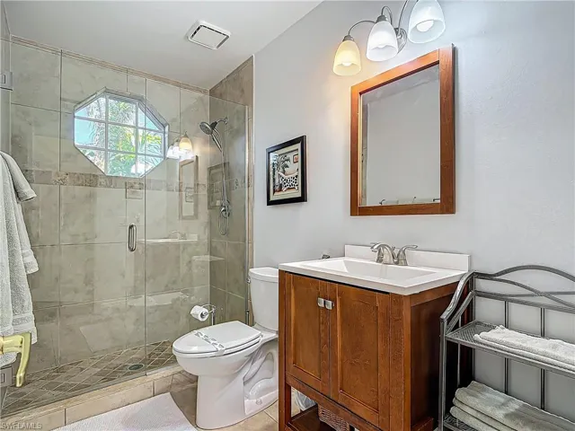Full bathroom featuring vanity, a shower stall, and tile patterned flooring