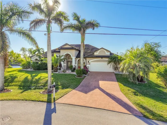 Mediterranean / spanish house with decorative driveway, stucco siding, a front yard, and a garage