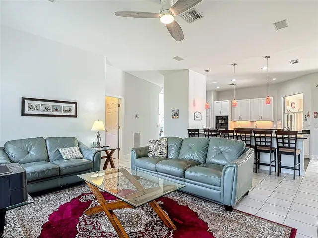Living room featuring light tile patterned floors, a ceiling fan, and recessed lighting
