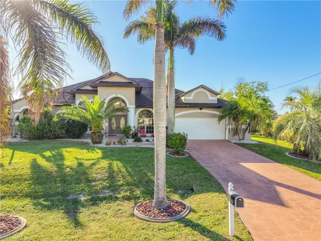 Mediterranean / spanish home with stucco siding, decorative driveway, a front lawn, and a garage