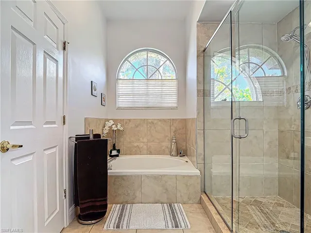 Bathroom featuring a shower stall, a garden tub, plenty of natural light, and tile patterned floors