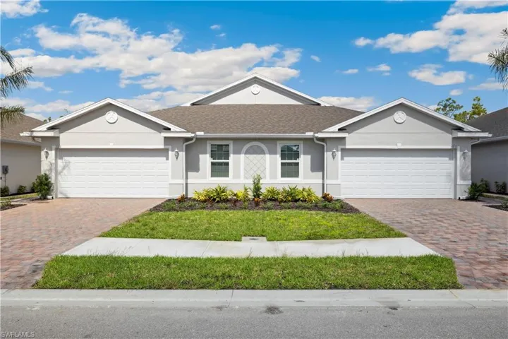 Single story home featuring a garage and a front lawn