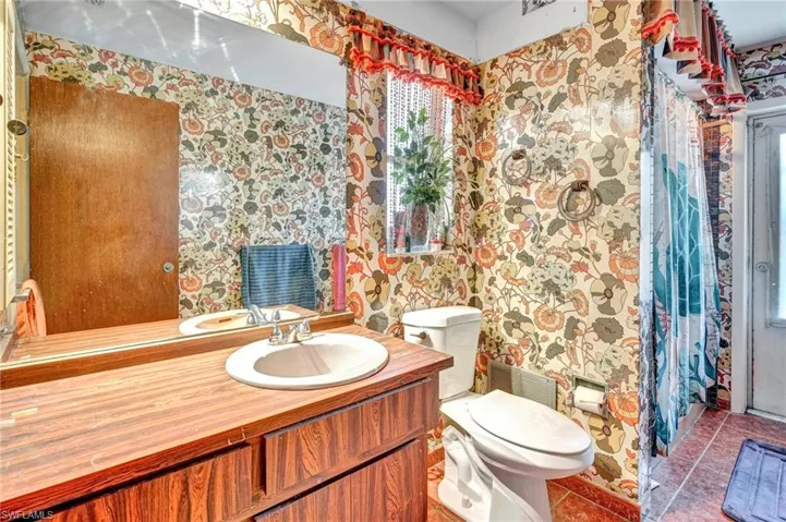 Bathroom featuring toilet, tile floors, and large vanity