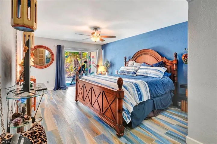 Bedroom with wood-type flooring, ceiling fan, and access to outside