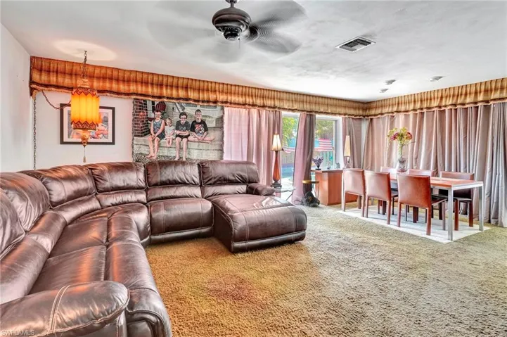 Carpeted living room with ceiling fan