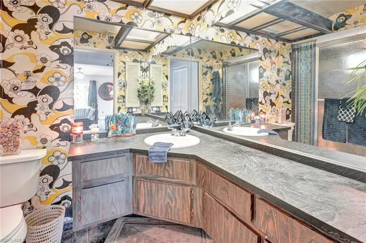 Bathroom featuring beam ceiling, tile flooring, large vanity, and toilet