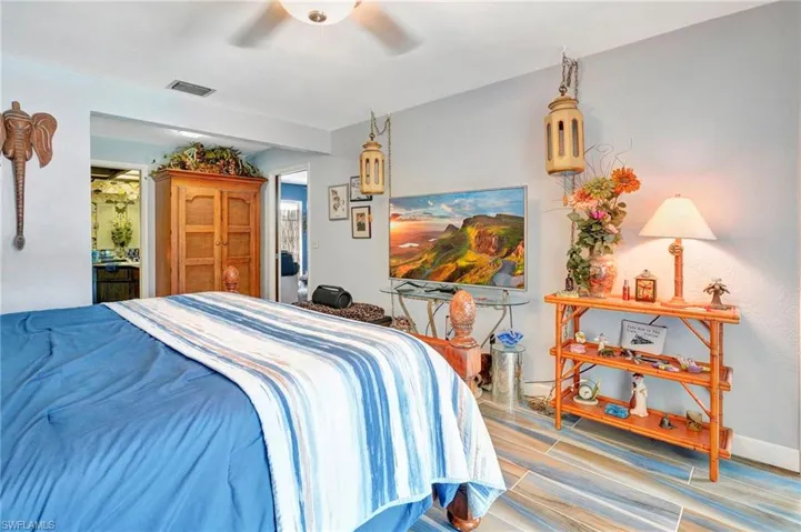 Bedroom with connected bathroom, ceiling fan, and hardwood / wood-style floors