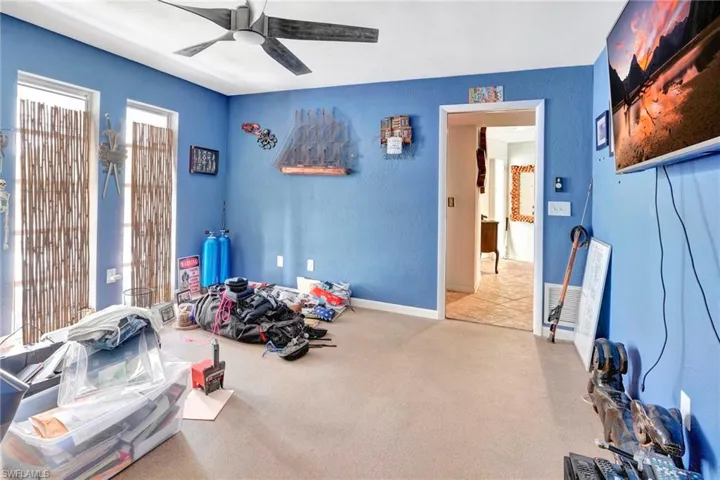 Exercise room with carpet flooring and ceiling fan