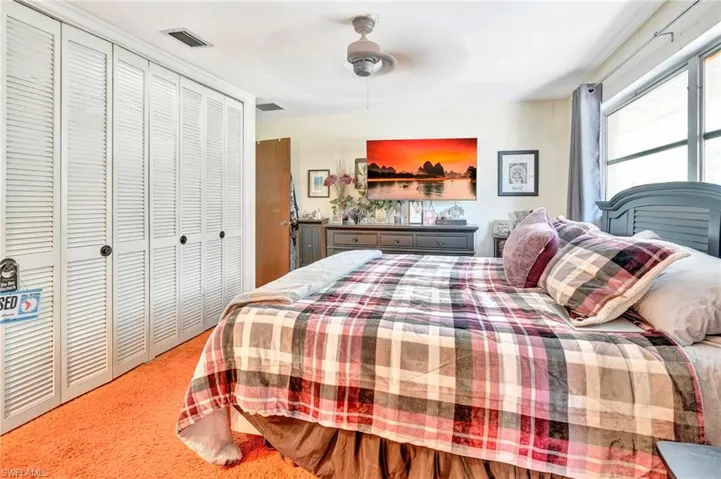 Bedroom featuring a closet, ceiling fan, and light colored carpet