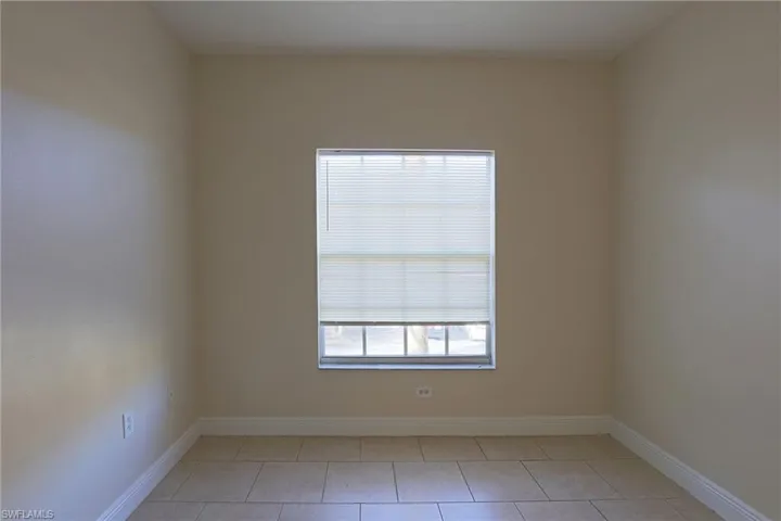 Unfurnished room featuring baseboards and light tile patterned flooring