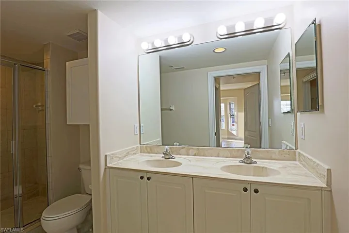 Bathroom featuring double vanity and a stall shower