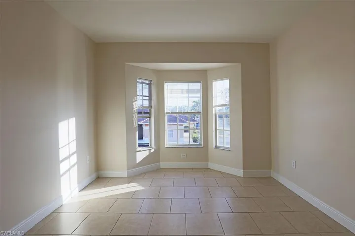 Empty room featuring baseboards and light tile patterned floors