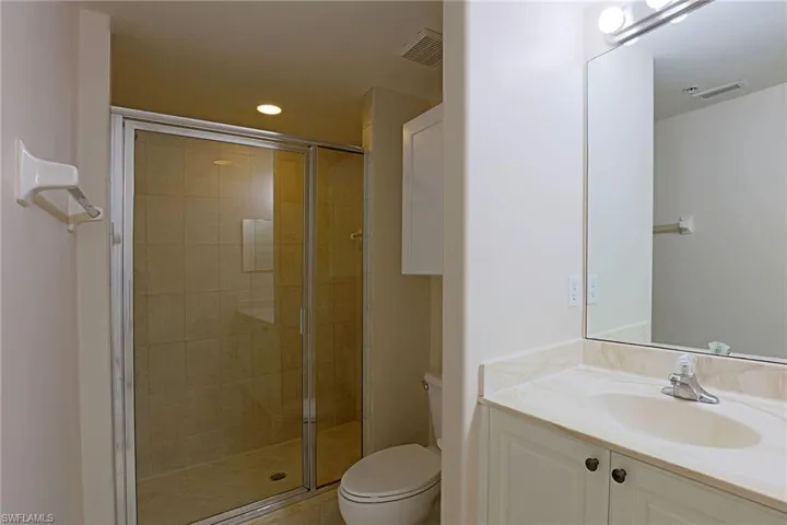 Full bath featuring vanity, a stall shower, and recessed lighting
