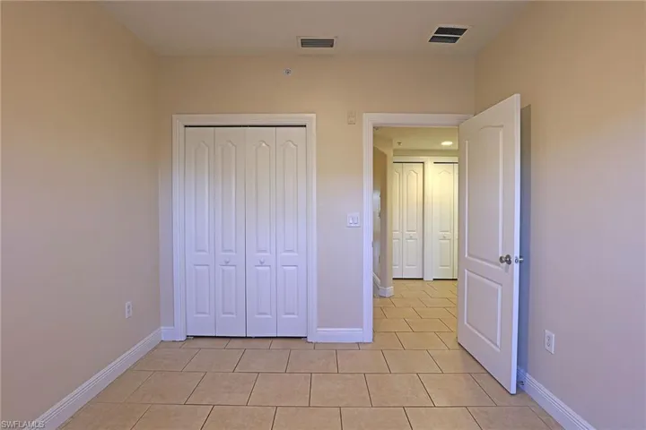 Unfurnished bedroom with light tile patterned floors and a closet