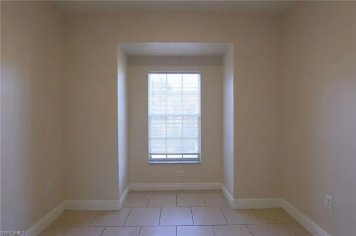 Spare room with baseboards and light tile patterned floors