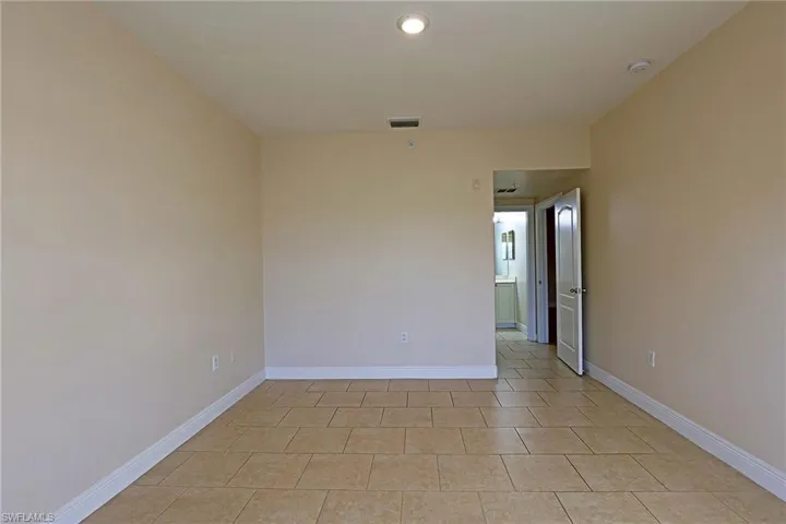 Empty room featuring baseboards and light tile patterned flooring