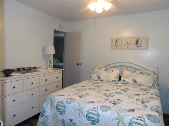 Bedroom with ceiling fan and dark wood-style flooring