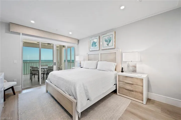 Bedroom featuring access to outside, light wood-type flooring, and a water view