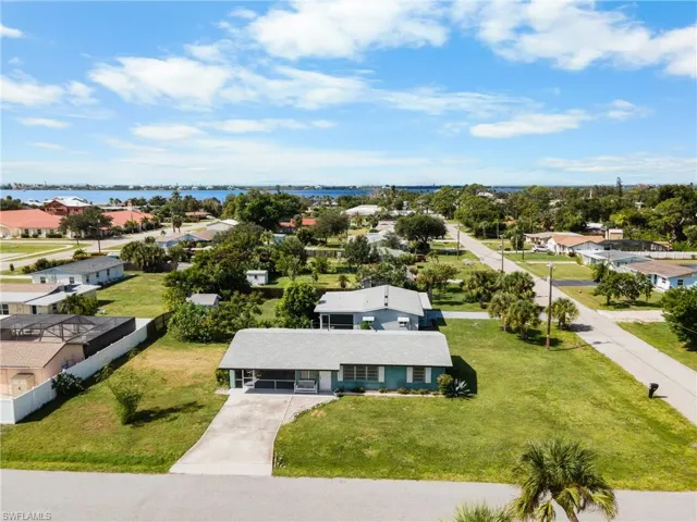 Single-story residence featuring a concrete driveway, covered front porch, and expansive lawn area