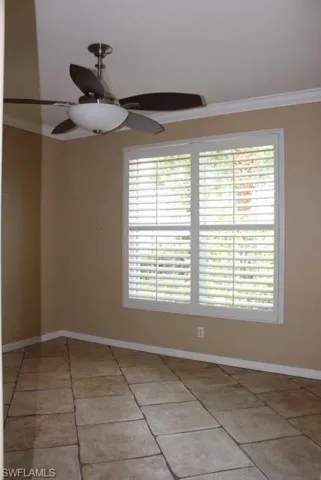Neutral-toned walls complement the large window with plantation shutters