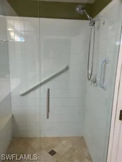 Walk-in shower with clear glass enclosure and a built-in bench