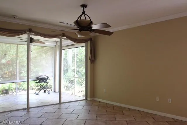 Spacious room featuring tile flooring, a screen-enclosed patio, and a ceiling fan with integrated lighting