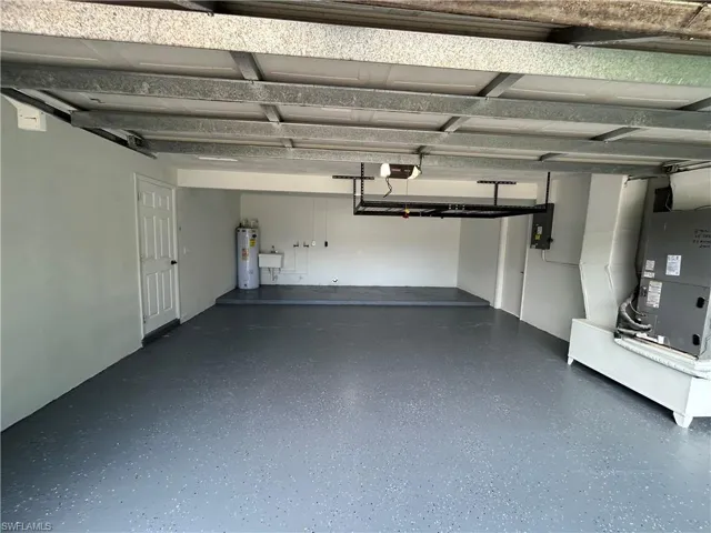 Garage with heating unit, electric water heater, and a garage door opener