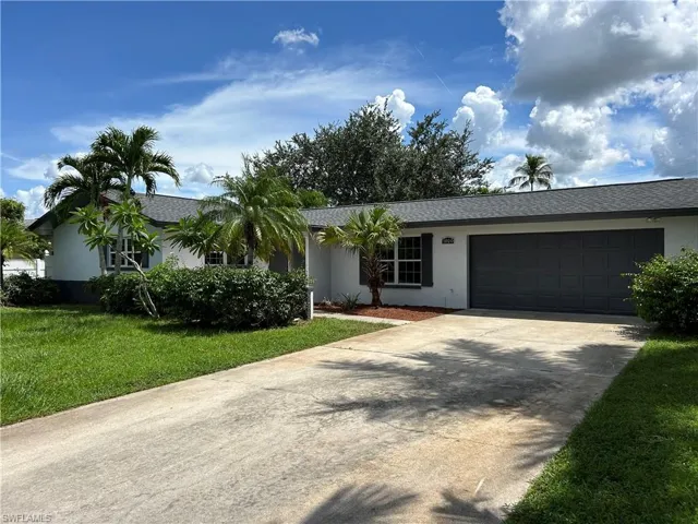 Ranch-style home with a front yard and a garage